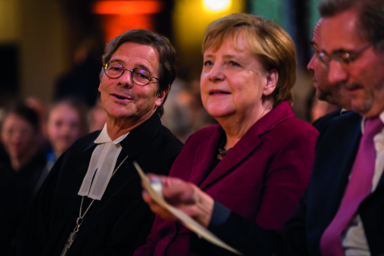 Bundeskanzlerin Angela Merkel, hier abgebildet mit Bischof Markus Dröge (l.), und Matthias Platzeck (r.), Vorsitzender der Kommission „30 Jahre Friedliche Revolution und Deutsche Einheit“, nahmen an der Gedenkveranstaltung teil.