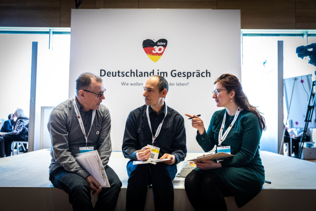 Two men and a woman are engrossed in a conversation during a dialogue event in Heilbronn.